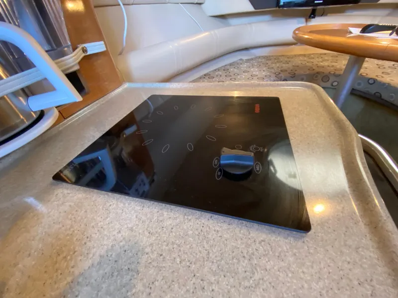 Slide: The Image of 2008 Larson Cabrio 240 boat interior with a sleek black cooktop. - 22