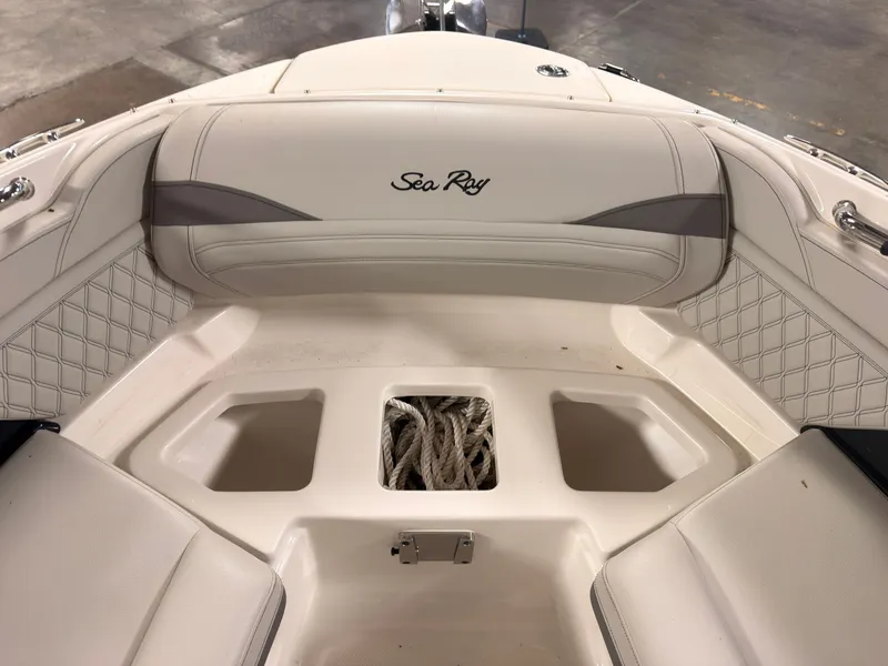 Slide: The Image of The image shows the bow area of a Sea Ray SLX 260 Surf boat with storage and cushions. - 47