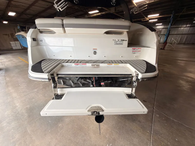 Slide: The Image of The image shows the stern of a 2024 Sea Ray SLX 260 Surf boat in a warehouse. - 8