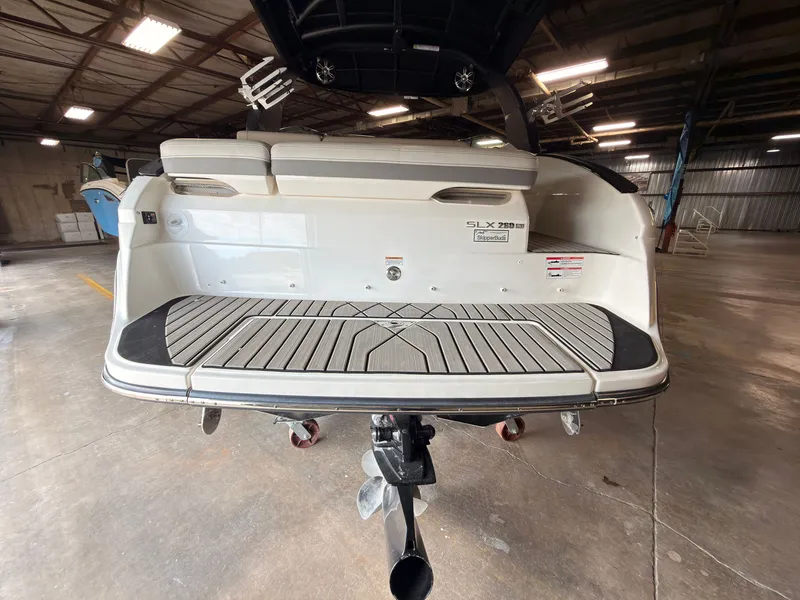 Slide: The Image of The image shows the stern of a 2024 Sea Ray SLX 260 Surf boat in a warehouse. - 7