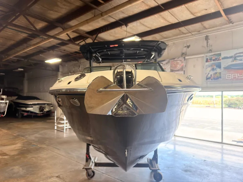 Slide: The Image of A 2024 Sea Ray SLX 260 Surf is in a warehouse. The bow is facing forward. - 4