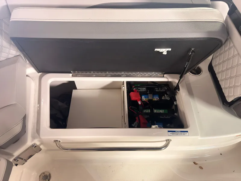 Slide: The Image of The 2024 Sea Ray SLX 260 Surf features an open storage compartment with batteries. - 21