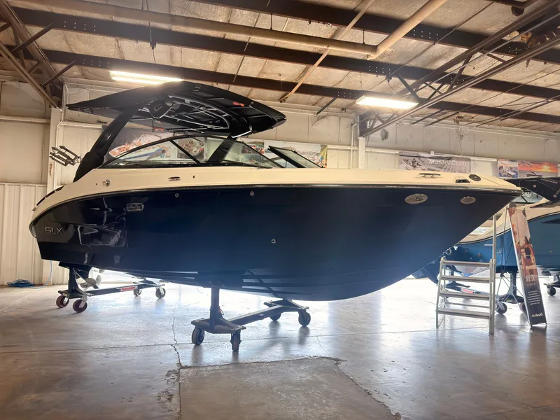 The Image of A 2024 Sea Ray SLX 260 Surf is on a stand in a warehouse. - 0