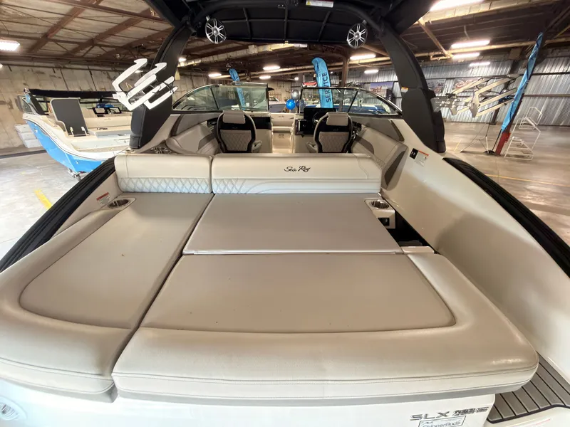 Slide: The Image of The image shows the stern of a 2024 Sea Ray SLX 260 Surf with beige upholstery. - 9