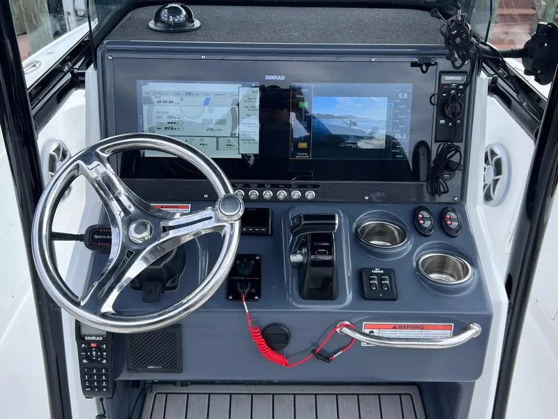 Slide: The Image of 2020 Crevalle 26 HCO Yamaha 300 boat dashboard with Simrad display and controls. - 30