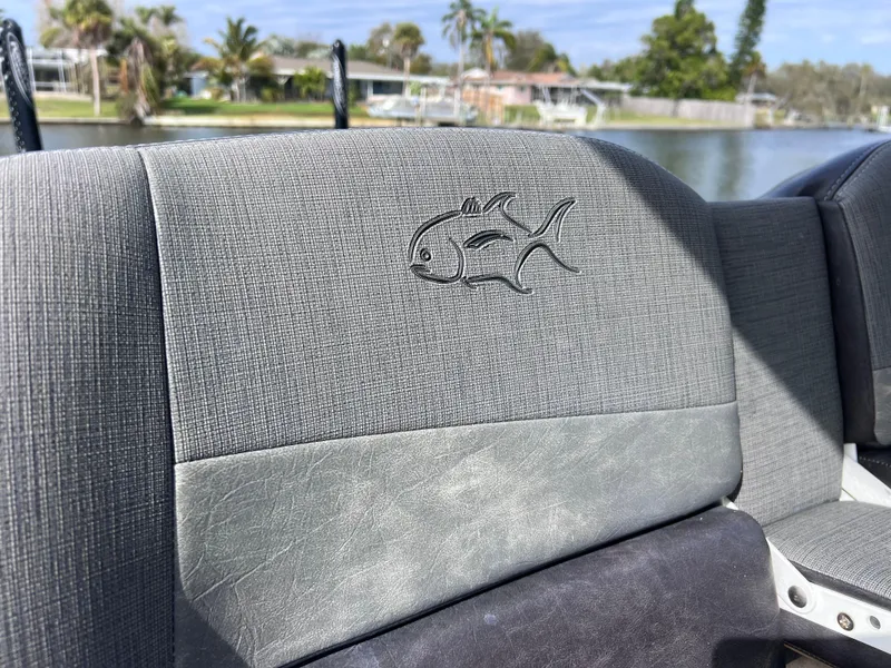 Slide: The Image of 2020 Crevalle 26 HCO Yamaha 300 boat seat with fish logo, waterfront background. - 49
