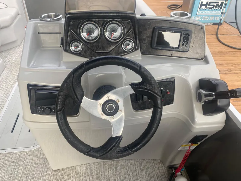 Slide: The Image of 2022 SunCatcher Select 322RC boat dashboard with steering wheel and control panel. - 11