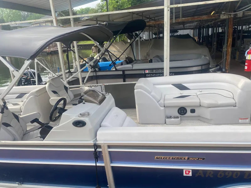 Slide: The Image of 2022 SunCatcher Select 322RC pontoon boat docked under a covered marina. - 2