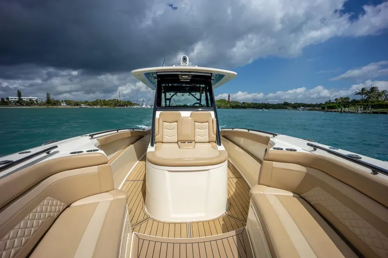 Slide: The Image of 2022 Scout 330 LXF boat with luxurious seating on a sunny day. - 12