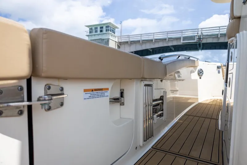 Slide: The Image of 2022 Scout 330 LXF boat interior with cushioned seating and teak flooring. - 21
