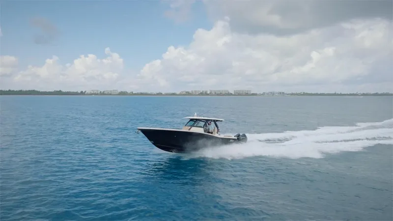 Slide: The Image of 2022 Scout 330 LXF boat cruising on open water. - 24