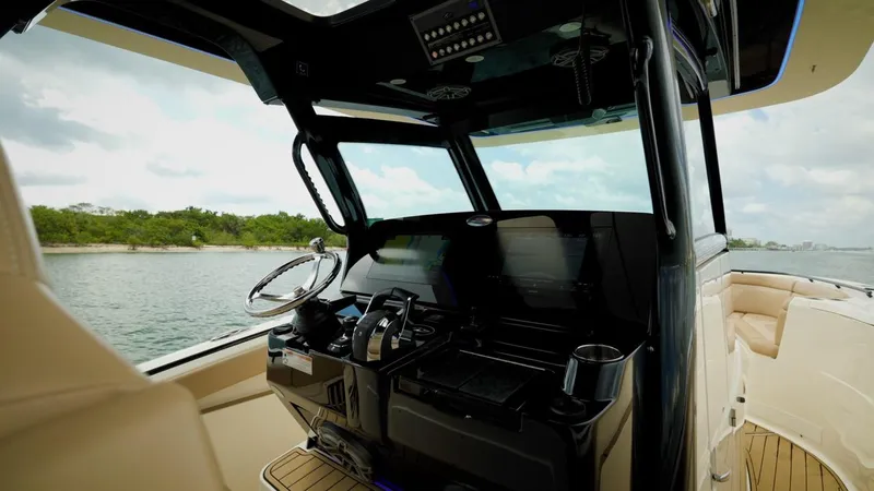 Slide: The Image of 2022 Scout 330 LXF boat cockpit with modern controls and scenic water view. - 6