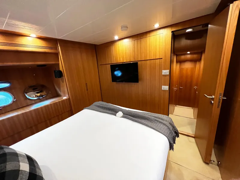 Slide: The Image of Luxurious bedroom on 2006 Sanlorenzo SL72 yacht with wood paneling and porthole windows. - 10