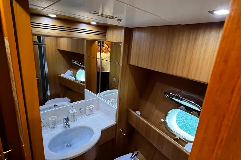 Slide: The Image of Luxurious bathroom in a 2006 Sanlorenzo SL72 yacht with wood paneling and porthole window. - 14