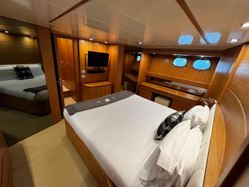 Slide: The Image of Luxurious bedroom on a 2006 Sanlorenzo SL72 yacht with wood paneling and modern amenities. - 6