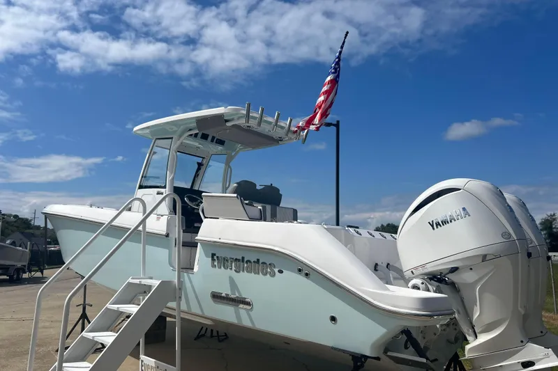 Slide: The Image of 2024 Everglades 285 Center Console boat with Yamaha engine, docked under blue sky. - 2