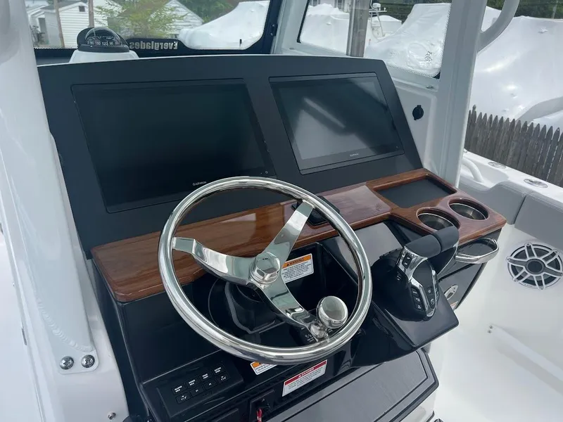 Slide: The Image of 2024 Everglades 285 Center Console boat dashboard with steering wheel and dual screens. - 23