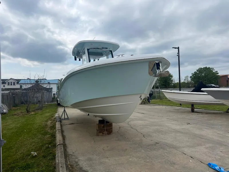 Slide: The Image of 2024 Everglades 285 Center Console boat on a concrete lot under a cloudy sky. - 6