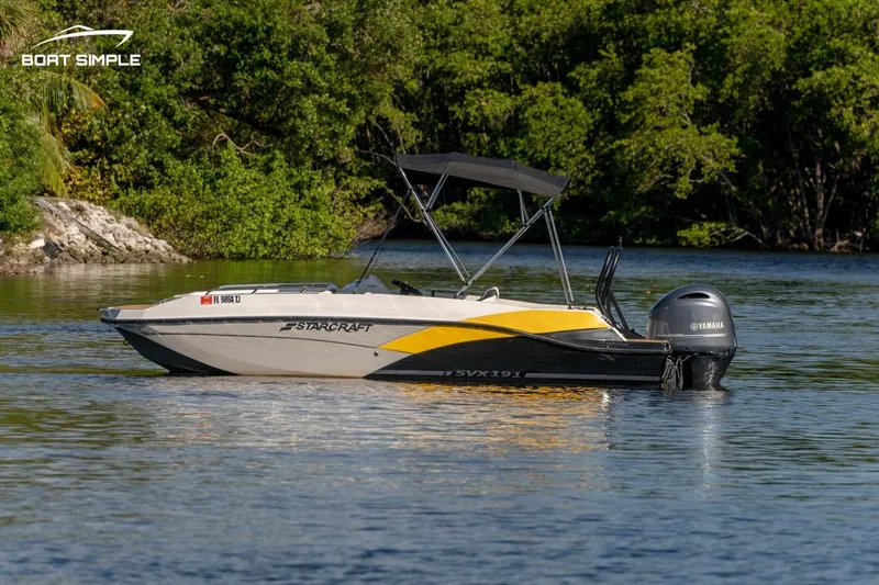 Slide: The Image of 2022 Starcraft SVX 191 OB boat on a calm lake with lush greenery. - 0