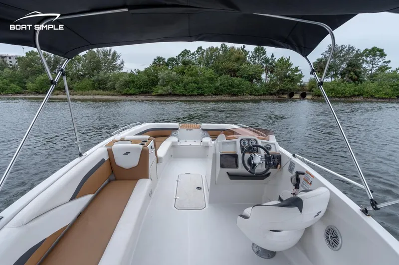 Slide: The Image of 2022 Starcraft SVX 211 OB boat interior with canopy, steering console, and seating. - 6