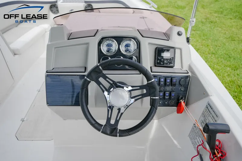 Slide: The Image of 2022 Starcraft SVX 231 OB boat dashboard with steering wheel and control panel. - 6