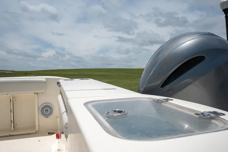 Slide: The Image of 2021 Cobia 201 Center Console boat with outboard motor and storage compartments. - 10