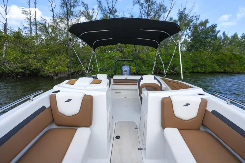 Slide: The Image of 2023 Starcraft SVX 210 OB boat with spacious seating and canopy on a serene waterway. - 10