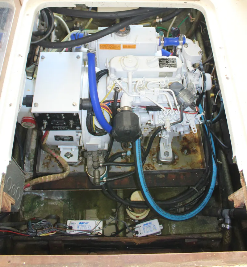 Slide: The Image of 1980 Bertram Sport Fisherman engine compartment with visible wiring and components. - 16