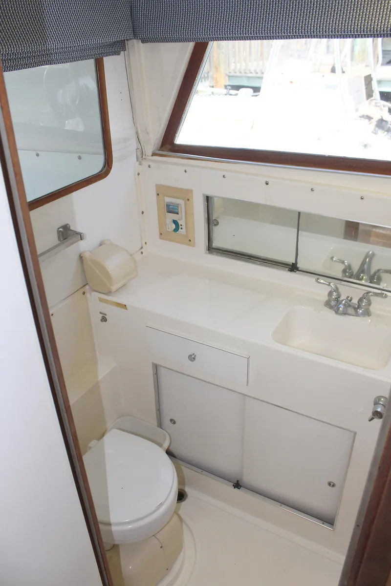 Slide: The Image of 1980 Bertram Sport Fisherman boat bathroom with sink, toilet, and mirror. - 23