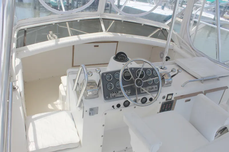 Slide: The Image of 1980 Bertram Sport Fisherman boat cockpit with steering wheel and control panel. - 7