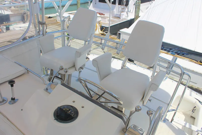 Slide: The Image of 1980 Bertram Sport Fisherman boat with white captain's chairs on deck. - 8