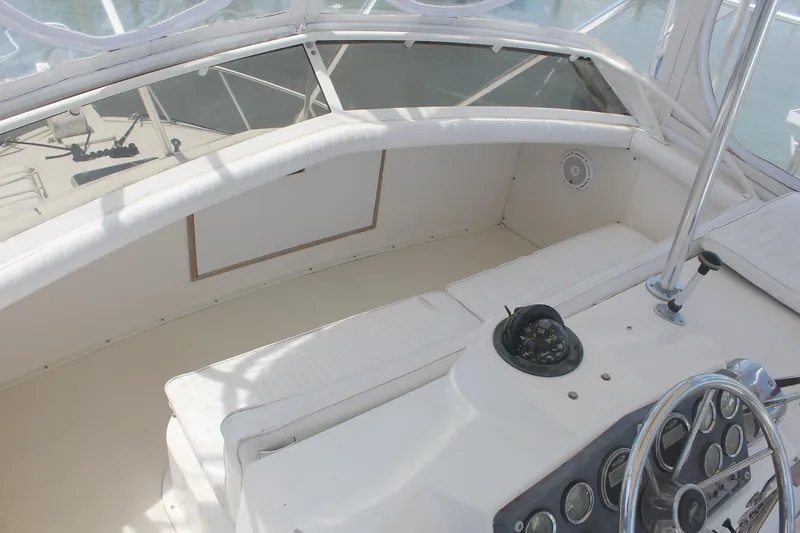 Slide: The Image of 1980 Bertram Sport Fisherman boat cockpit with white seating and control panel. - 9