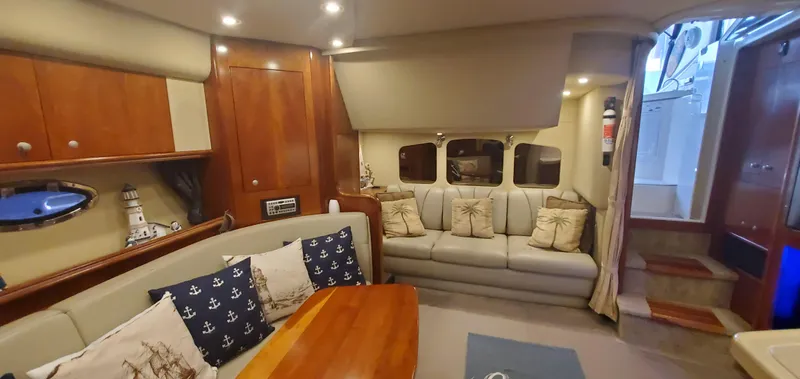 Slide: The Image of Interior of 2006 Cruisers Yachts 370 Express, featuring cozy seating and nautical decor. - 10