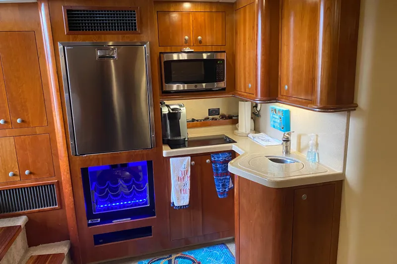 Slide: The Image of 2006 Cruisers Yachts 370 Express kitchen with wood cabinets, stainless appliances, and modern amenities. - 13