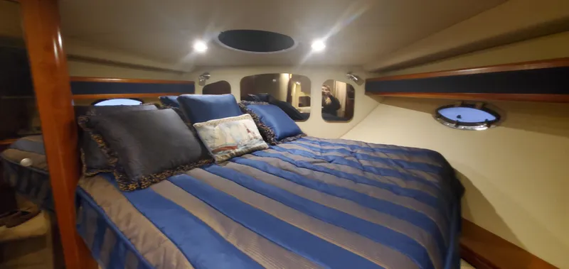 Slide: The Image of Luxurious cabin interior of 2006 Cruisers Yachts 370 Express with striped bedding. - 17