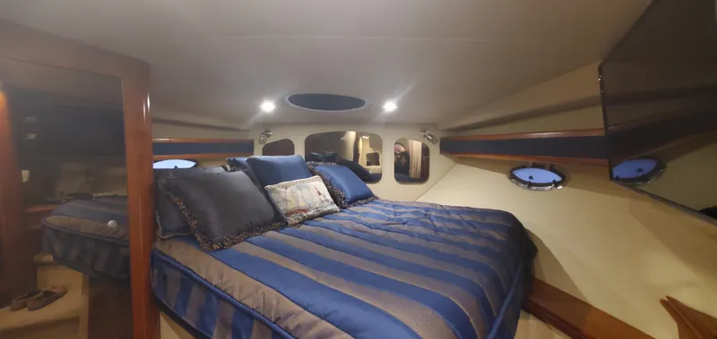 Slide: The Image of Luxurious cabin interior of 2006 Cruisers Yachts 370 Express with blue bedding. - 18