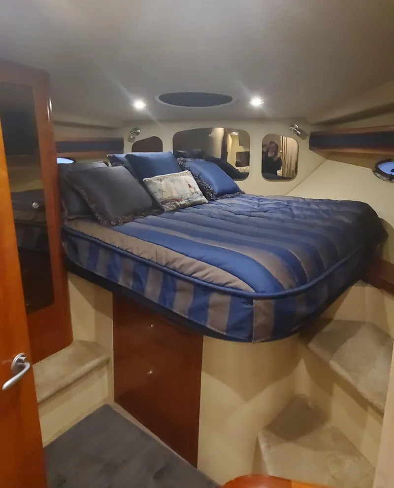Slide: The Image of 2006 Cruisers Yachts 370 Express cabin with a cozy bed and elegant interior. - 19
