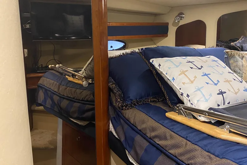 Slide: The Image of Interior of 2006 Cruisers Yachts 370 Express with nautical-themed bedding and cozy cabin space. - 20