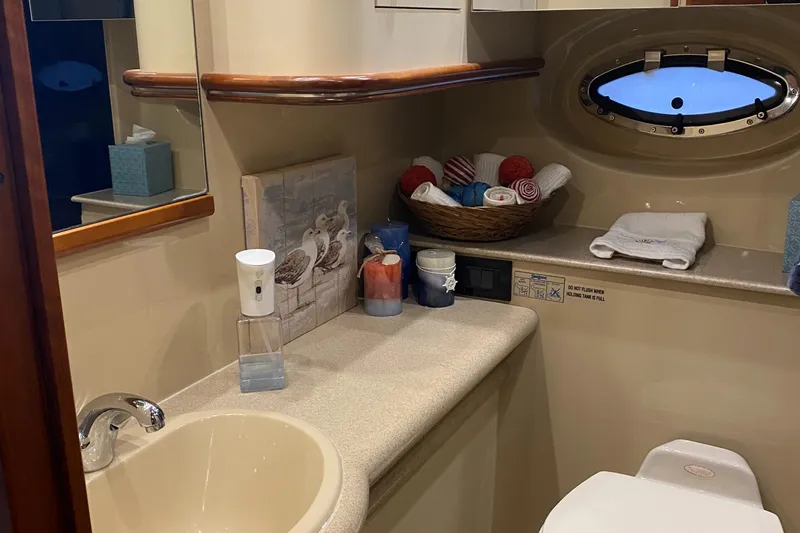 Slide: The Image of 2006 Cruisers Yachts 370 Express bathroom with sink, mirror, and porthole window. - 25