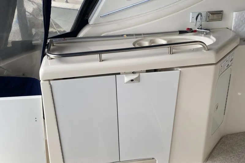 Slide: The Image of 2006 Cruisers Yachts 370 Express kitchenette with sink and storage cabinets. - 7
