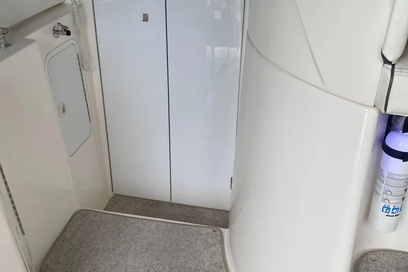 Slide: The Image of 2006 Cruisers Yachts 370 Express interior with white cabinetry and carpeted flooring. - 8