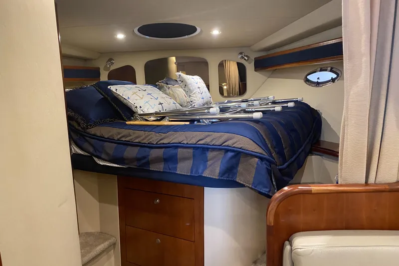 Slide: The Image of 2006 Cruisers Yachts 370 Express cabin with bed, pillows, and wooden storage. - 16