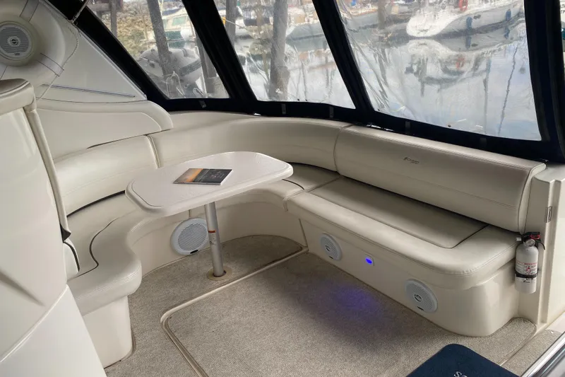 Slide: The Image of 2006 Cruisers Yachts 370 Express interior with curved seating and table, featuring large windows. - 6