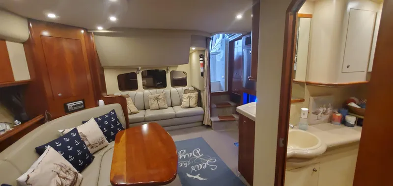Slide: The Image of Interior of 2006 Cruisers Yachts 370 Express, featuring cozy seating and elegant wood finishes. - 9