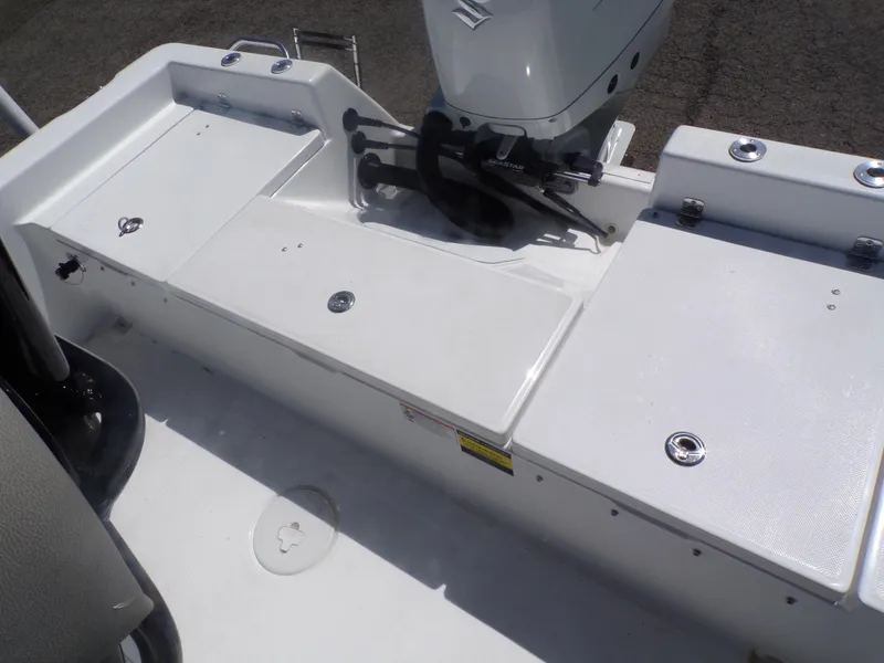 Slide: The Image of 2024 Savannah 210X boat deck with storage compartments and outboard motor. - 13