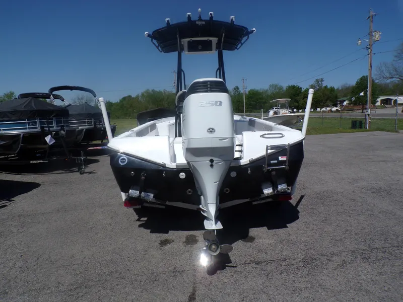 Slide: The Image of 2024 Savannah 210X boat, rear view with outboard motor, parked on asphalt. - 2