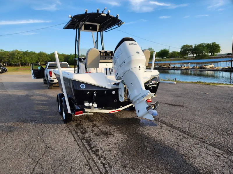 Slide: The Image of 2024 Savannah 210X boat on trailer near a lake. - 24