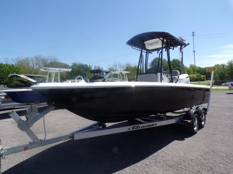 Slide: The Image of 2024 Savannah 210X boat on EZ Loader trailer, black hull, T-top, parked outdoors. - 8