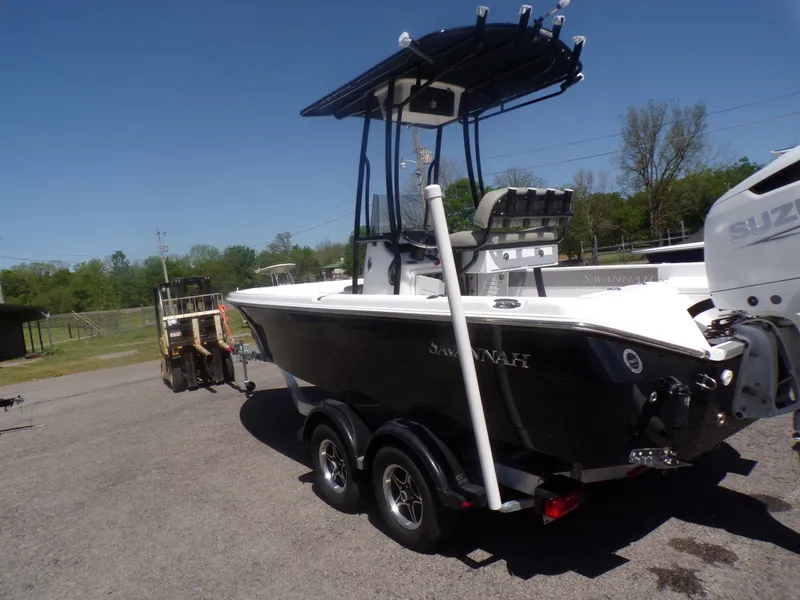 Slide: The Image of 2024 Savannah 210X boat on trailer, black hull, center console, outdoor setting. - 9
