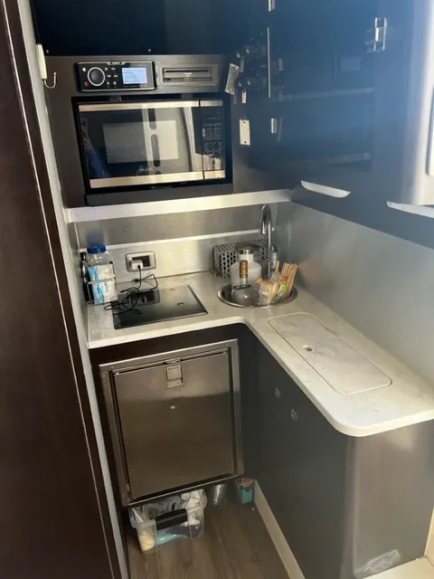 Slide: The Image of Compact kitchen area in a 2018 Scout 380 LXF boat with microwave and sink. - 5